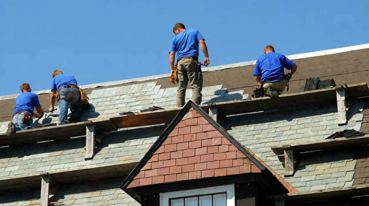 Roof replacement in progress with a team of professional contractors installing new shingles on a residential home in Tallahassee, FL